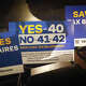 Yes on 40 signs sit on seats at the “Ballots Over Billionaires” rally on Monday, Oct. 5, 2026, in Los Angeles.
