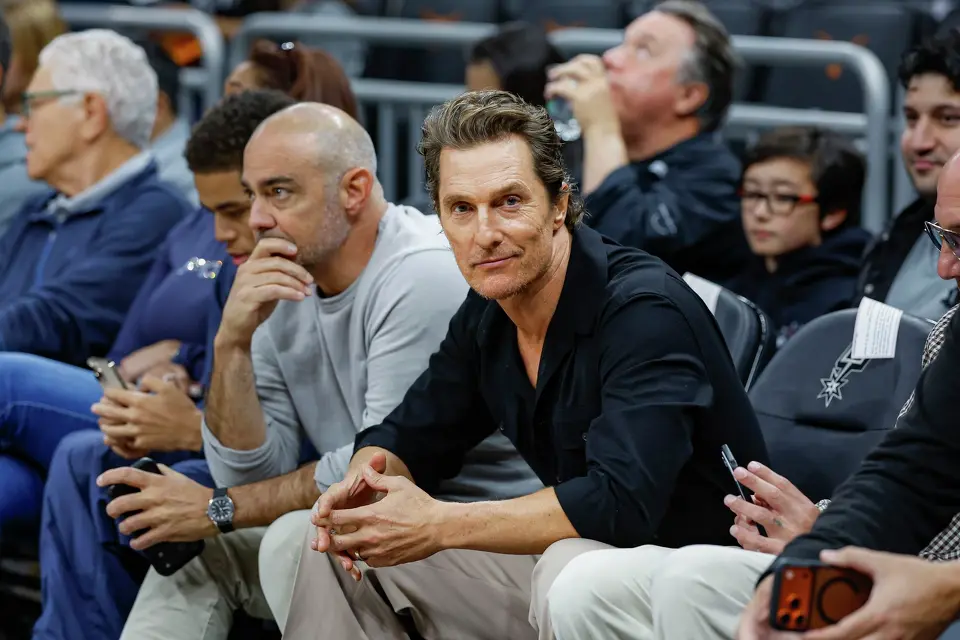 Matthew McConaughey, center, sits courtside for the Houston Rockets versus San Antonio Spurs game at Moody Center in Austin, Friday, Oct. 23, 2026.