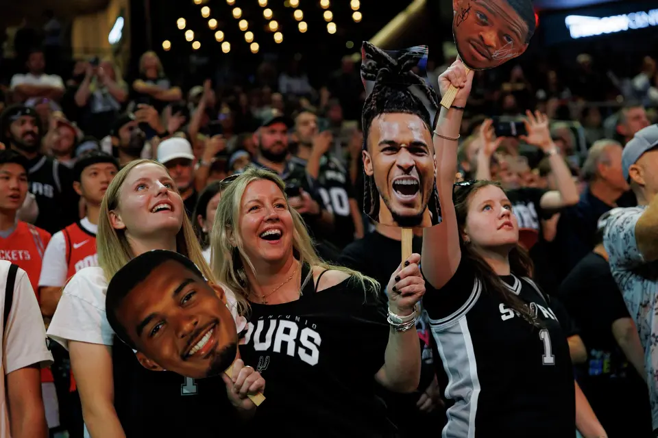 Cooper, from left, Shannon and Mary Muller cheer on the San Antonio Spurs as they attend the Spurs game against the Houston Rockets at Moody Center in Austin, Friday, Oct. 23, 2026.