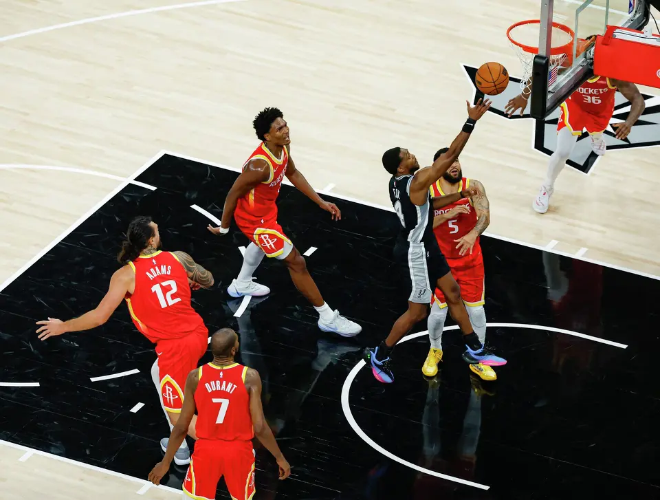 San Antonio Spurs guard De'aaron Fox (4) drives to the basket over Houston Rockets guard Fred Vanvleet (5) during the second quarter at Moody Center in Austin, Friday, Oct. 23, 2026.