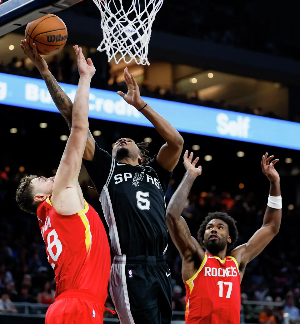 San Antonio Spurs guard Stephon Castle (5) goes up for a shot around Houston Rockets center Alperen Sengun (28) and forward Tari Eason (17) during the fourth quarter at Moody Center in Austin, Friday, Oct. 23, 2026. The Spurs fell 114-110 to the Rockets.