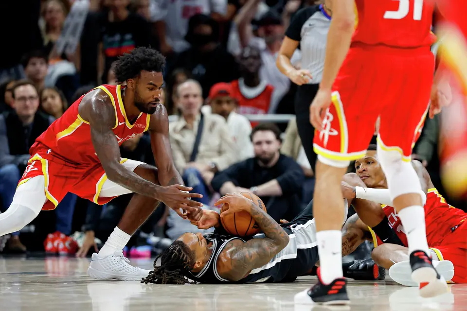 San Antonio Spurs guard Devin Vassell (24) fights for a loose ball with Houston Rockets forwards Tari Eason (17) and Jabari Smith Jr. (10) during the fourth quarter at Moody Center in Austin, Friday, Oct. 23, 2026. The Spurs fell 114-110 to the Rockets.