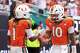 Miami wide receiver Malachi Toney (1) celebrates with quarterback Darian Mensah (10) after scoring a touchdown against Pittsburgh during the first half of an NCAA college football game, Saturday, Oct. 24, 2026, in Miami Gardens, Fla.