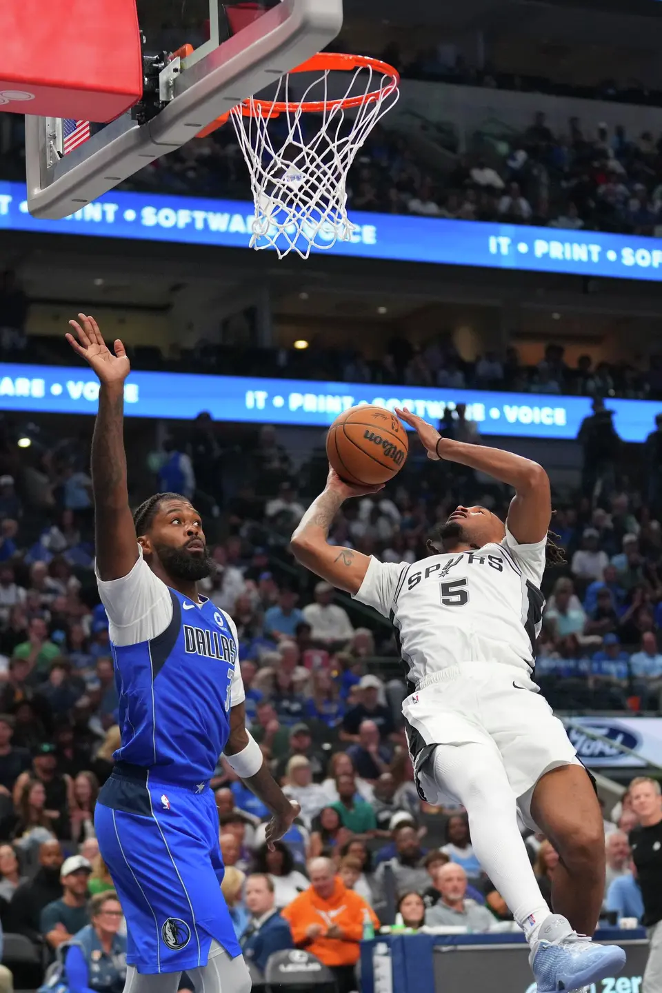 San Antonio Spurs guard Stephon Castle (5) throws up a shot against Dallas Mavericks forward Naji Marshall (3) during the second half of an NBA basketball game Saturday, Oct. 24, 2026, in Dallas. (AP Photo/Julio Cortez)