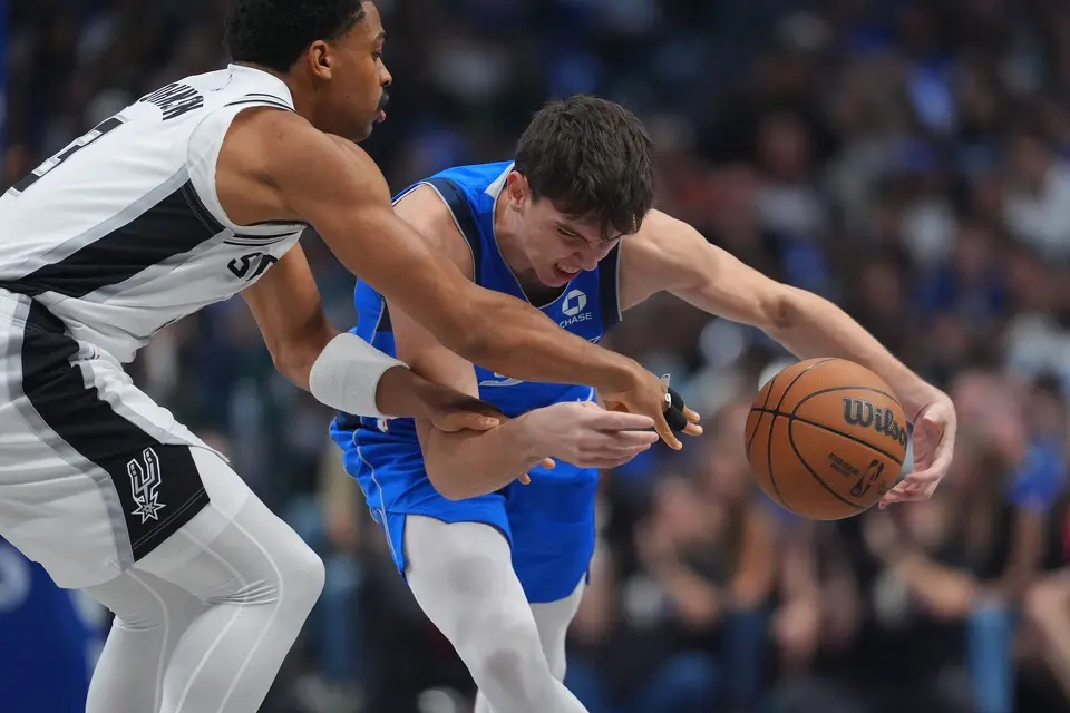 Dallas Mavericks forward Sergio de Larrea drives against San Antonio Spurs forward Keldon Johnson during the first half of an NBA basketball game Saturday, Oct. 24, 2026, in Dallas. (AP Photo/Julio Cortez)