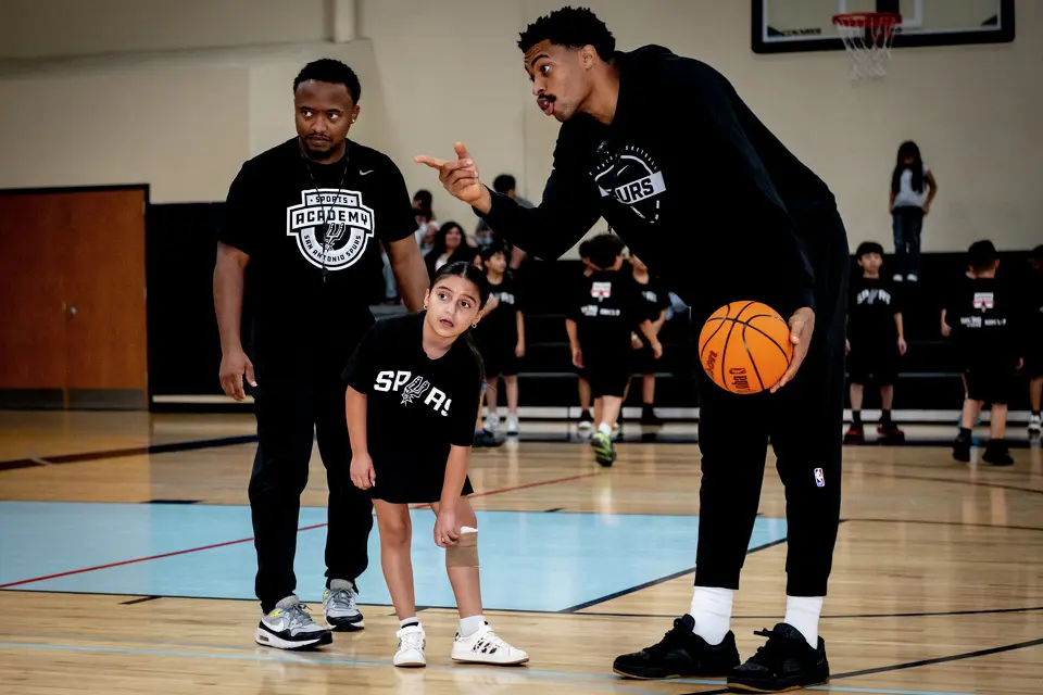 October 26, 2026, San Antonio, TX: San Antonio Spurs guard Keldon Johnson talks to a young girl as they play basketball together during a RBFCU Spurs Youth Basketball League clinic at CentroMed Health & Wellness Clinic in San Antonio, Texas Monday, October 26, 2026. (Photo by Reginald Thomas II/San Antonio Spurs)