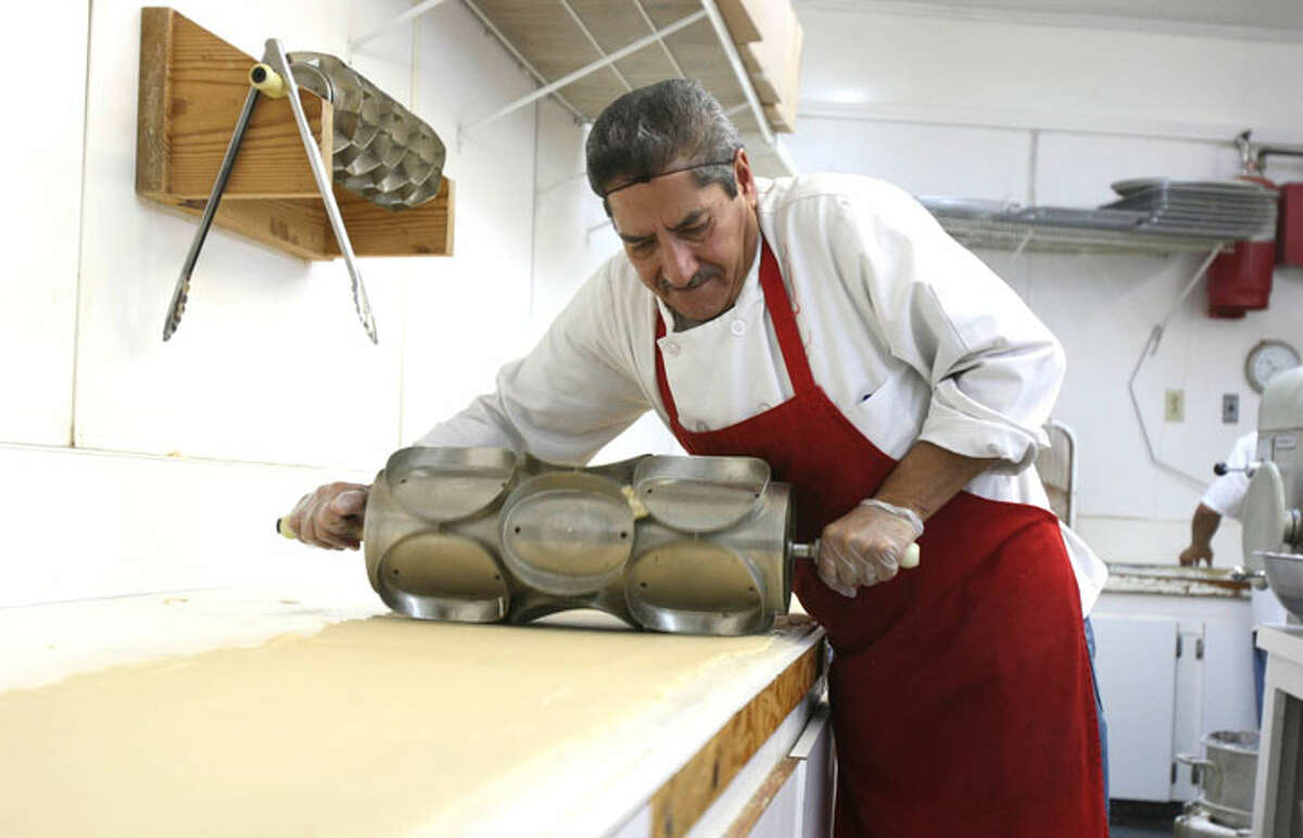 Rafael Chapa cuts the dough into round pieces before they head for the fryer at the The Original HemisFair Buñuelo company. The company has been making the sweet treats since 1968. HELEN L. MONTOYA/hmontoya@express-news.net
