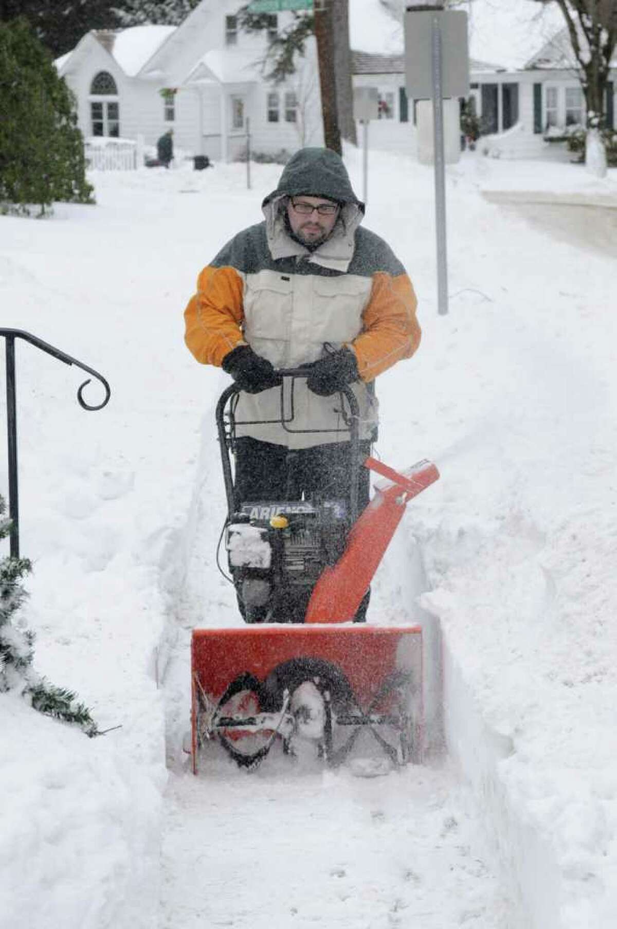 Roma Le Blanc, uses his snow thrower to clear a path on the sidewalk in front of his Danbury home on, Monday, Dec. 27, 2010.