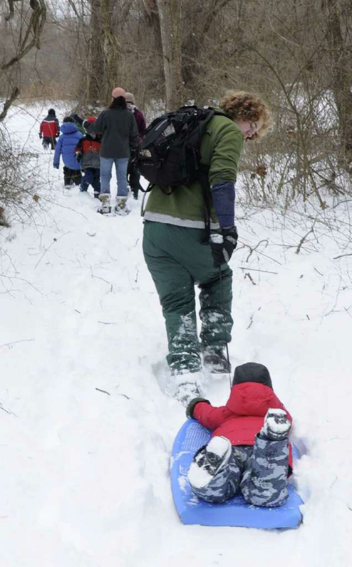 Camp counselor Calder Gladstone, 19, pulls Eli Adjmi , 5, on a sled during a hike held at the Pratt Nature Center winter camp in New Milford on Tuesday, Dec. 28, 2010.
