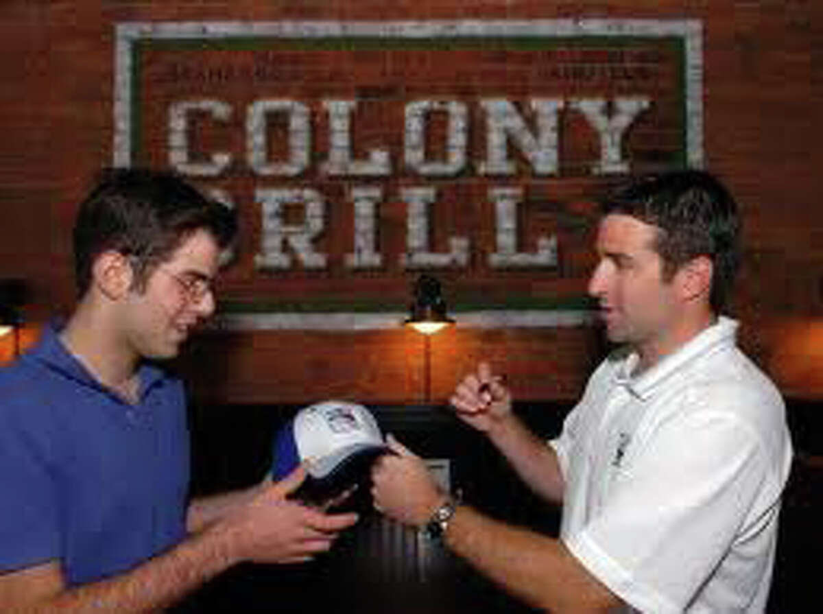 Rangers captain Chris Drury, right, signs an autograph for a fan at the Colony Grill's operning earlier this year. Drury is a co-owner of the pizza parlor and brought a film crew and some teammates by in November to tape a feature for the New York Rangers pre-game show that will air Saturday at 7 p.m. on the Madison Square Garden network.