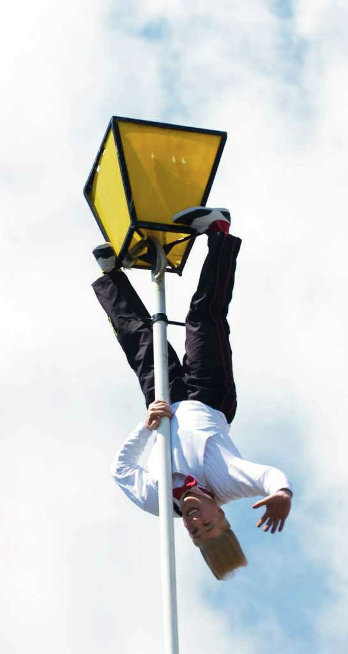 Bello Nock, the most famous daredevil clown, and star of the Big Apple Circus hangs upside down as he performs a stunt atop a 92 foot pole in Columbus Park on Tuesday May 4, 2010 in Stamford, Conn. The performance was to promote the Big Apple Circus' 32nd allñnew show, Bello is Back! as it makes its first ever appearance under the Big Top in Mill River Park from July 9 through July 25.
