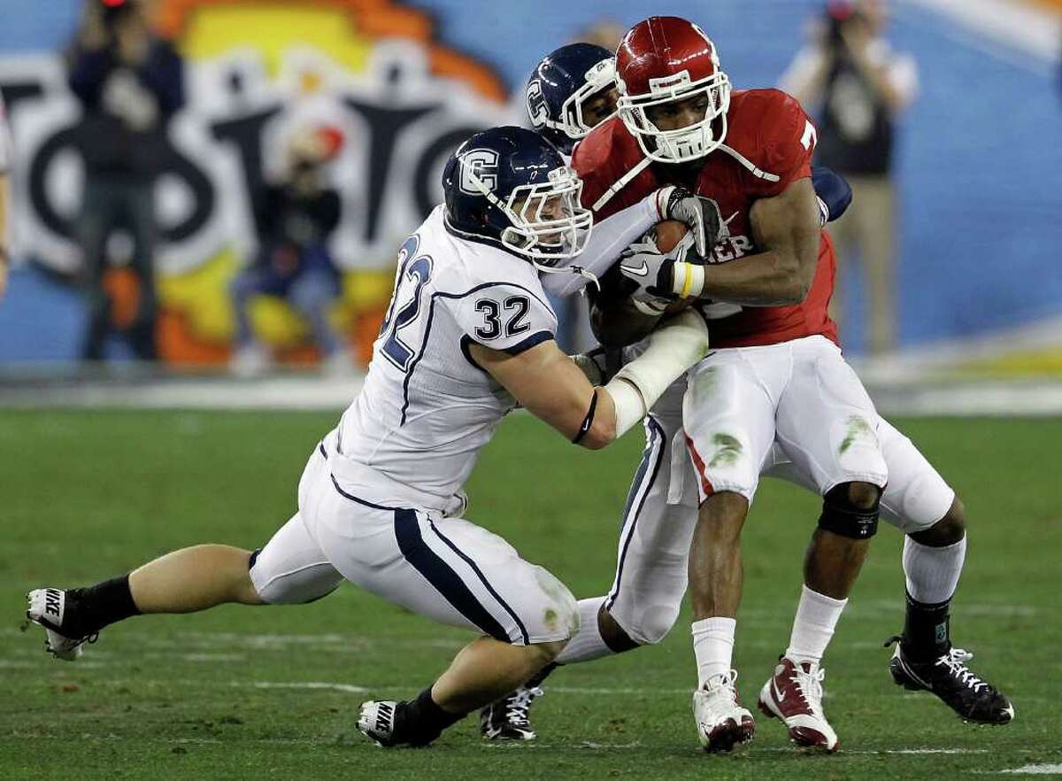 GLENDALE, AZ - JANUARY 01: DeMarco Murray #7 of the Oklahoma Sooners runs the ball as Scott Lutrus #32 of the Connecticut Huskies attempts to take it away in the first half during the Tostitos Fiesta Bowl at the Universtity of Phoenix Stadium on January 1, 2011 in Glendale, Arizona. (Photo by Tom Pennington/Getty Images) *** Local Caption *** DeMarco Murray;Scott Lutrus