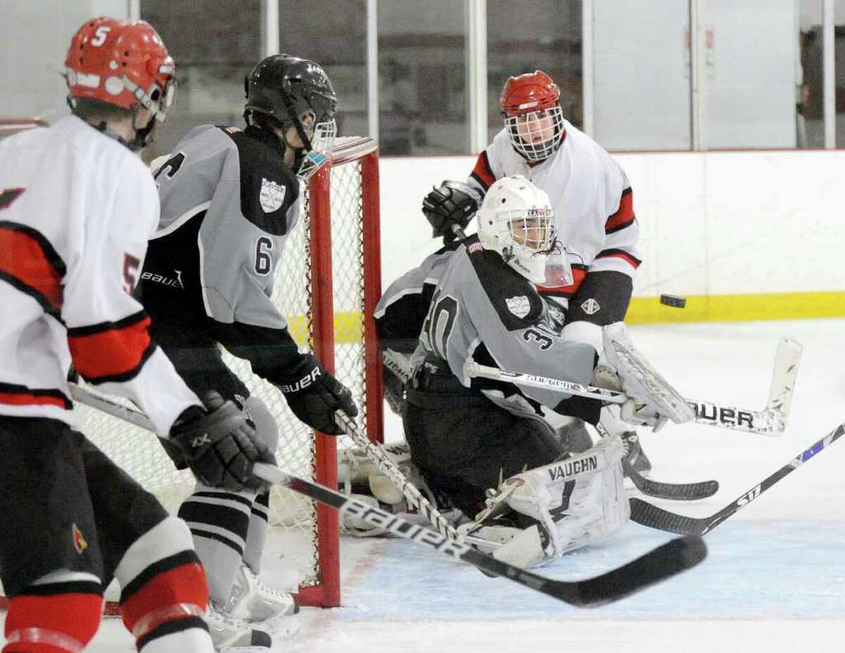 Alex Liebers of GHS, #9, right, attempts to play the rebound on a blocked shot by Xavier goalie, Austin Essery, # 30, as Gibby McHugh, # 5 of GHS, left, looks on along with Xavier's Evan Lindquist, # 6, during the Greenwich High School vs. Xavier High School, boys ice hockey game, Hamill Rink, Byram, Tuesday night, Jan. 4, 2011.