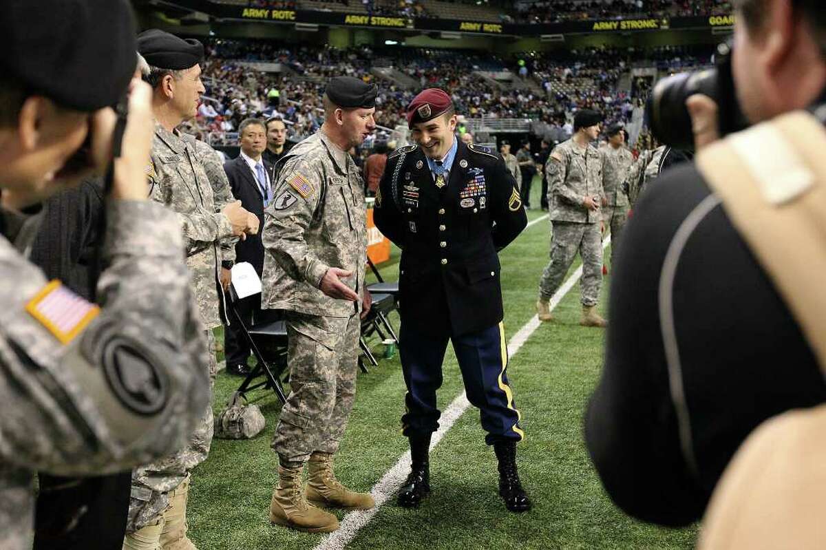 Medal of Honor recipient Salvador Giunta (center) makes an appearance at the 2011 U.S. Army All-American Bowl at the Alamodome on Saturday, Jan. 8, 2011. The best players from high school showcase their talents at the game packed with fans, family and soldiers. Giunta is the first living person to receive the medal and had performed the coin toss prior the game. Kin Man Hui/kmhui@express-news.net