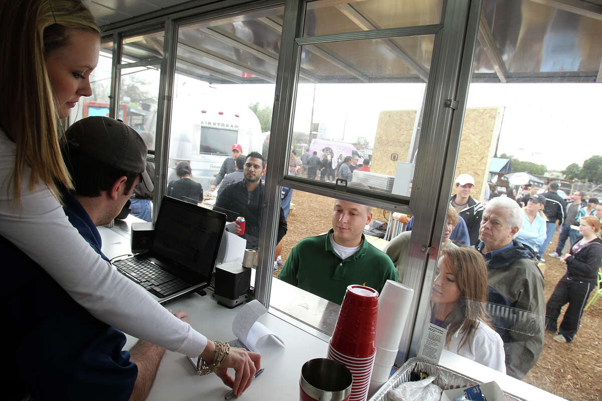 Jessie Mangum (left) and Travis Mangum take orders from customers at K Hill BBQ Company during the grand opening of the Boardwalk on Bulverde. The wait at many of the food stations Saturday was a half-hour or more.