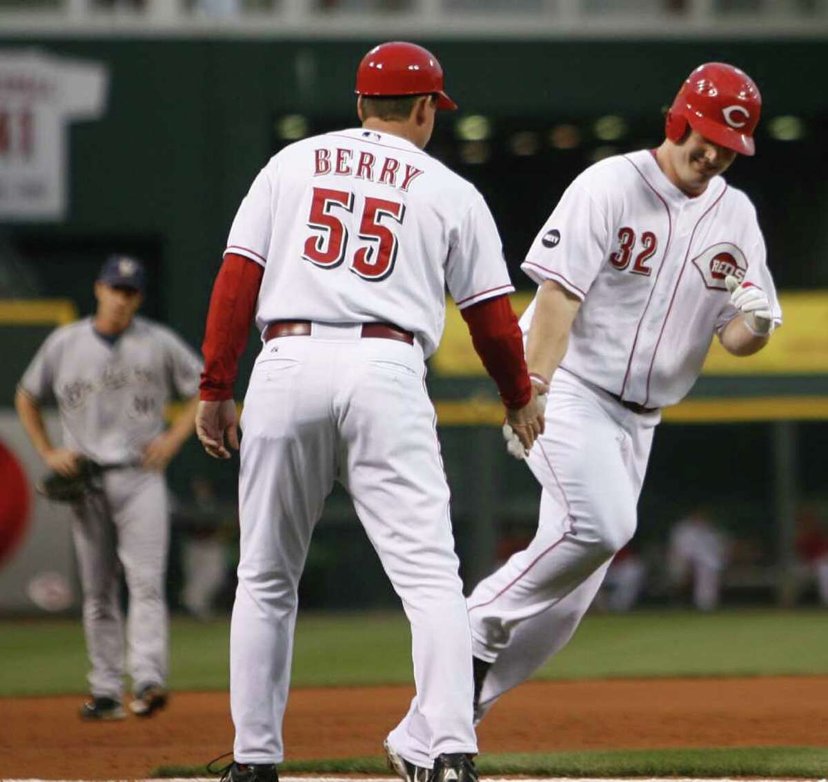Cincinnati Reds' Jay Bruce (32) is congratulated by third base coach Mark Berry (55) after Bruce hit a two-run home run off Milwaukee Brewers pitcher Jeff Suppan in the first inning during a baseball game, Friday, Sept. 19, 2008, in Cincinnati. (AP Photo/David Kohl)