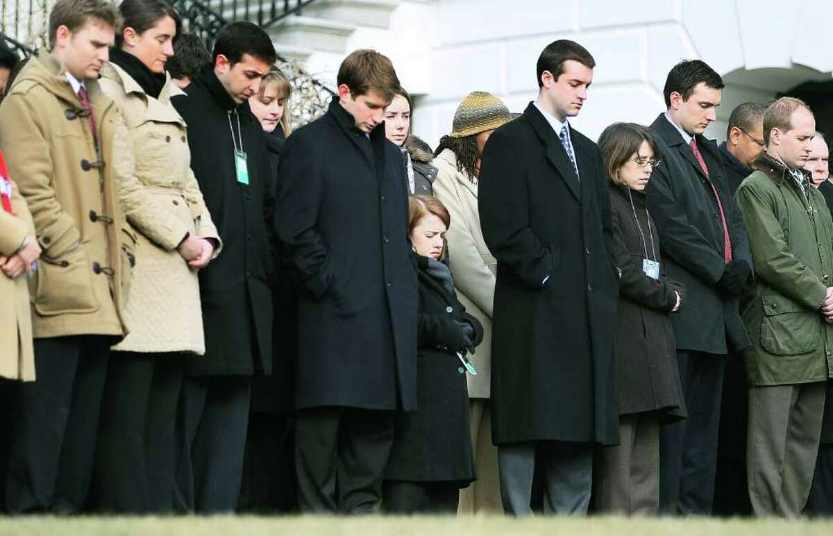 WASHINGTON, DC - JANUARY 10: White House staff observe a moment of silence to honor those killed and wounded during a shooting in Tucson, Arizona ouside the White House on January 10, 2011 in Washington, DC. President Barack Obama called on the nation to observe a moment of silence today at 11:00am in honor of the six people killed and at least 13 others wounded including U.S. Rep. Gabrielle Giffords (D-AZ) when a gunman opened fire at a public event held at Tucson Safeway supermarket. (Photo by Mark Wilson/Getty Images) *** Local Caption *** Michele Obama;Barack Obama