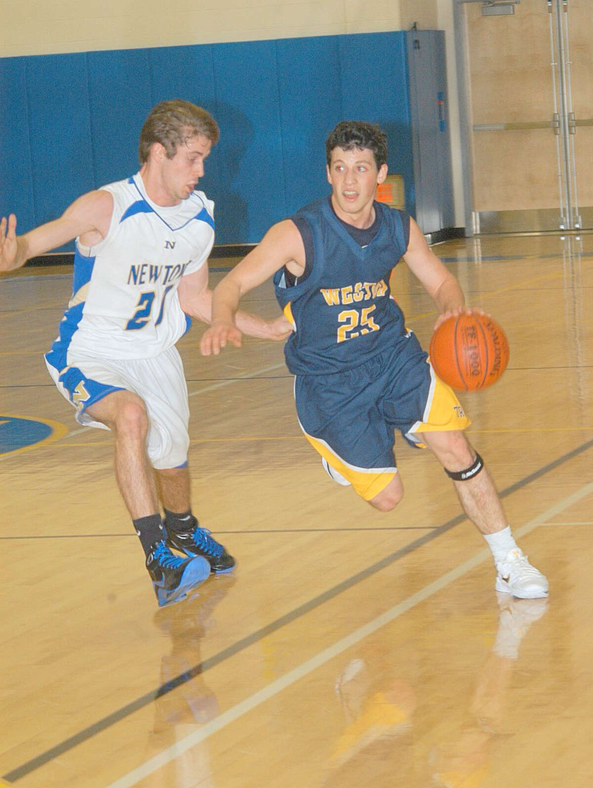 Weston junior Max Molinsky tries to drive past Newtown senior co-captain Josh Engler on Monday in a 55-25 loss to the Nighthawks.