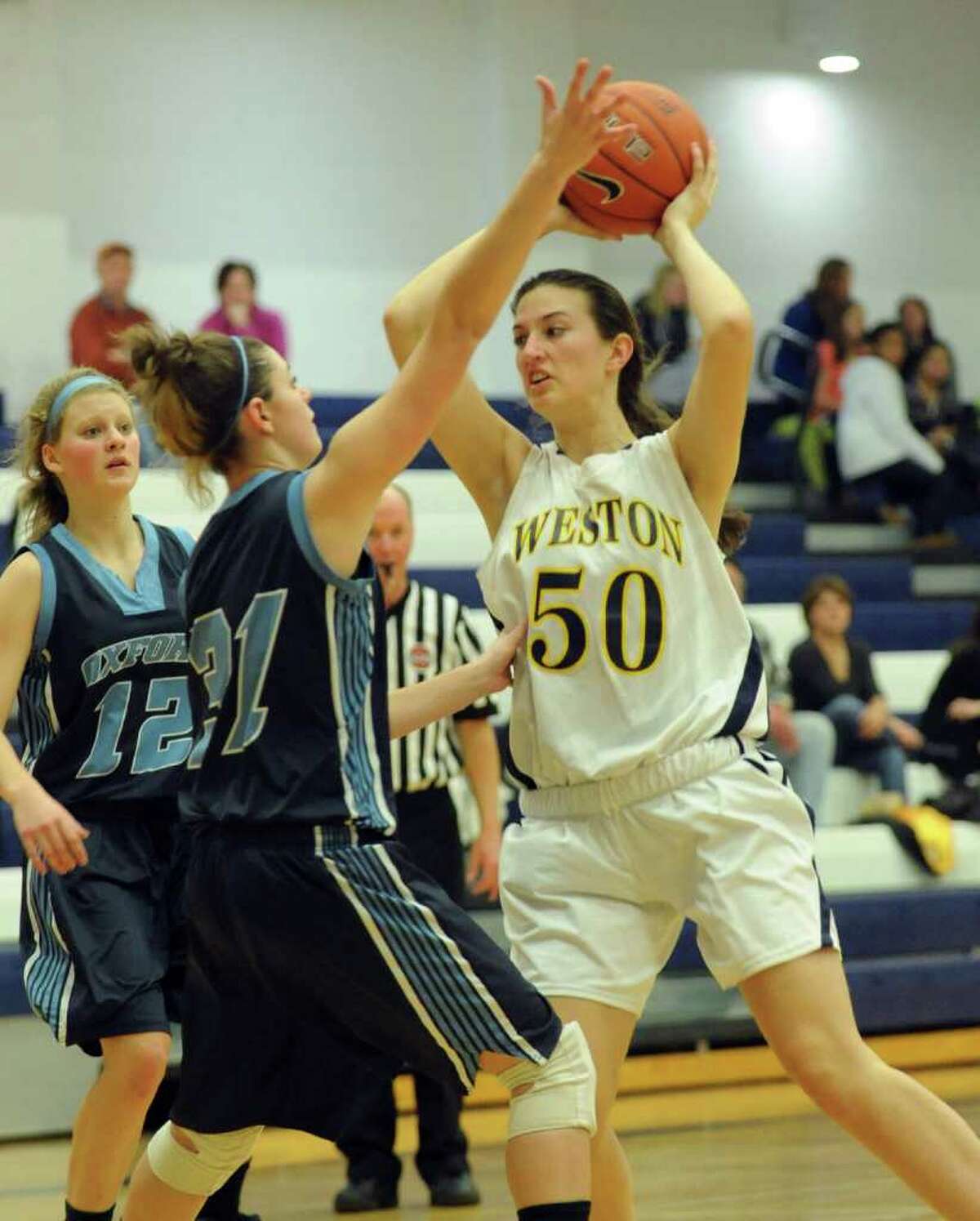 Weston girls basketball action against Oxford at Weston High School in Weston, Conn. on Friday January 14, 2011. Weston's #50 Anna Mahoney looks to pass over Oxford's #31 Rhiannon Bacik.