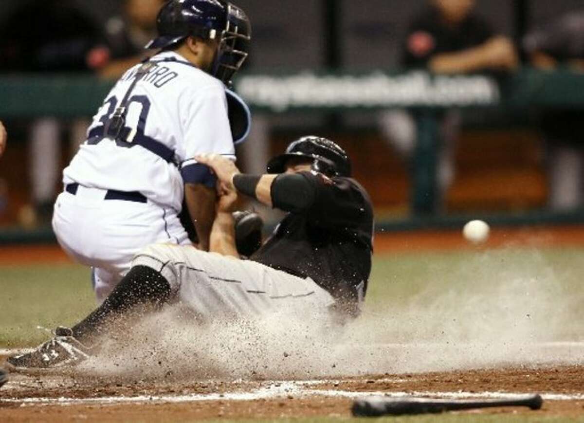 Toronto Blue Jays' Kevin Millar slides safely home ahead of the tag by Tampa Bay Rays catcher Dioner Navarro in the seventh inning of a baseball game Wednesday, July 8, 2009, in St. Petersburg, Fla. (AP Photo/Brian Blanco)