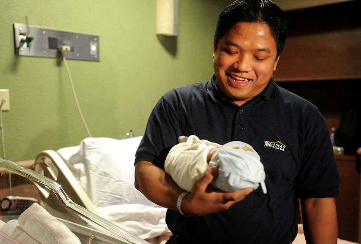 Randy Umayam poses with his newborn son, Joshua Umayam at Baptist Hospital in Beaumont. Joshua was born at 12:05 am on January 1, 2009. Tammy McKinley/
