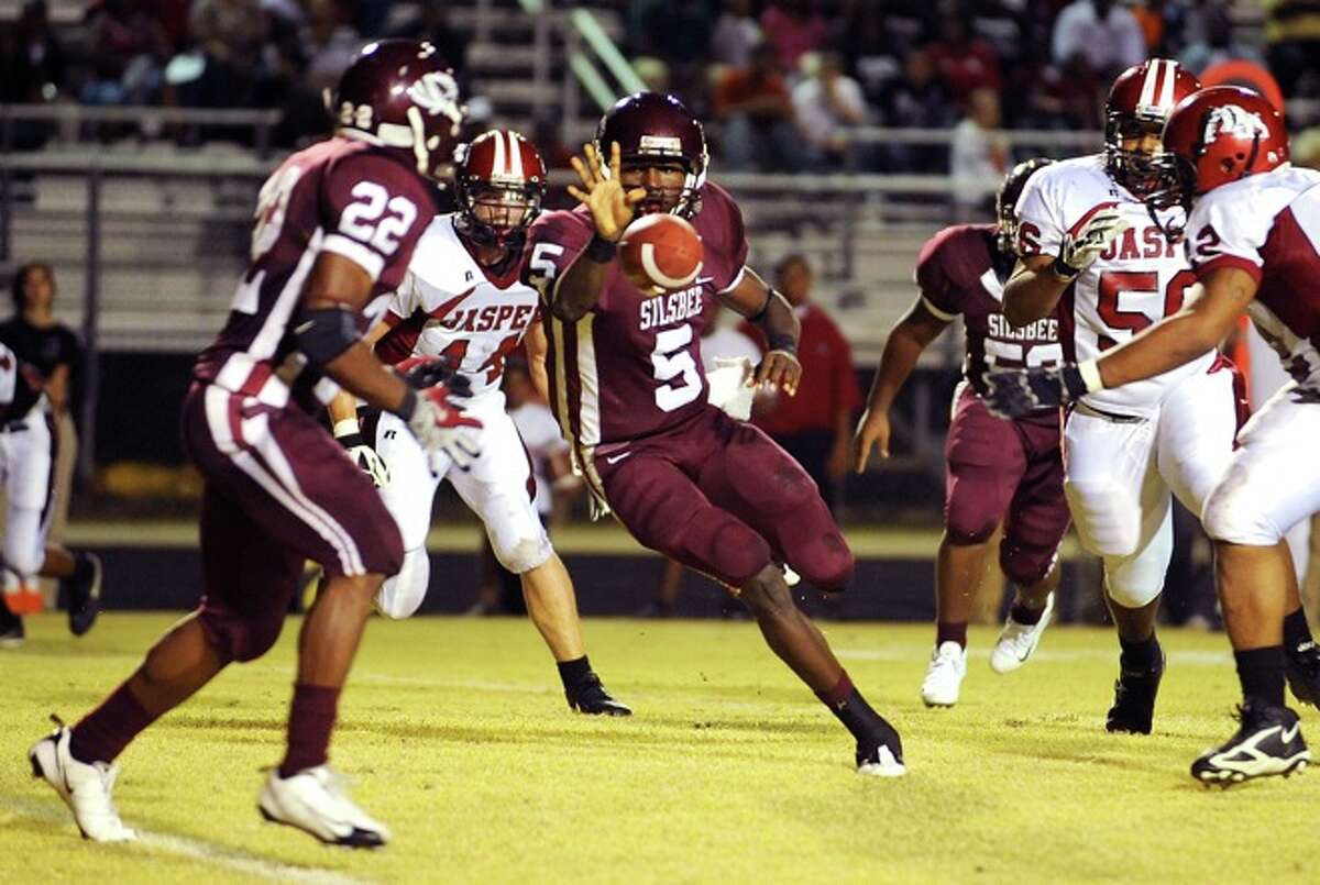 Silsbee's Jeremy Johnson passes the ball off to Chris Barnes for a short gain against Jasper at the Tiger's stadium Friday night. Guiseppe Barranco/