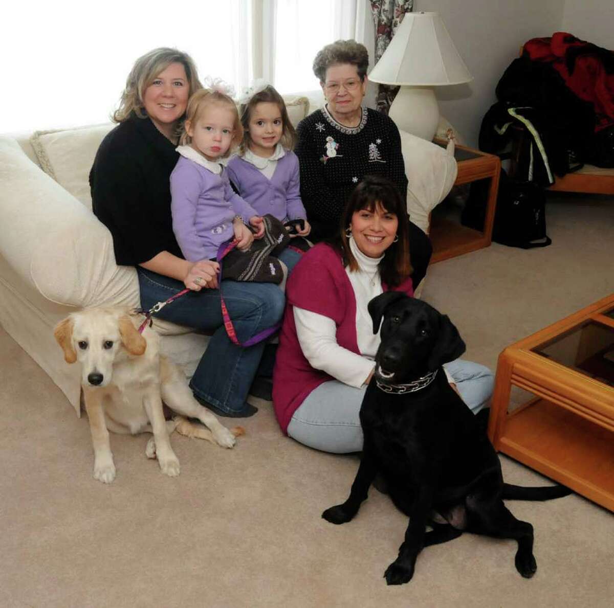 Barbie Mable, front, is reunited with some of the dogs she found homes for on Friday Jan. 14, 2011 at her home in New Fairifield. From left, Debra Mitchell of Southbury with her two daughters, Addison, 3, and Kaitlyn, 5, and the families dog ,Molly. Betty Speglevin of Danbury and her dog Lola.