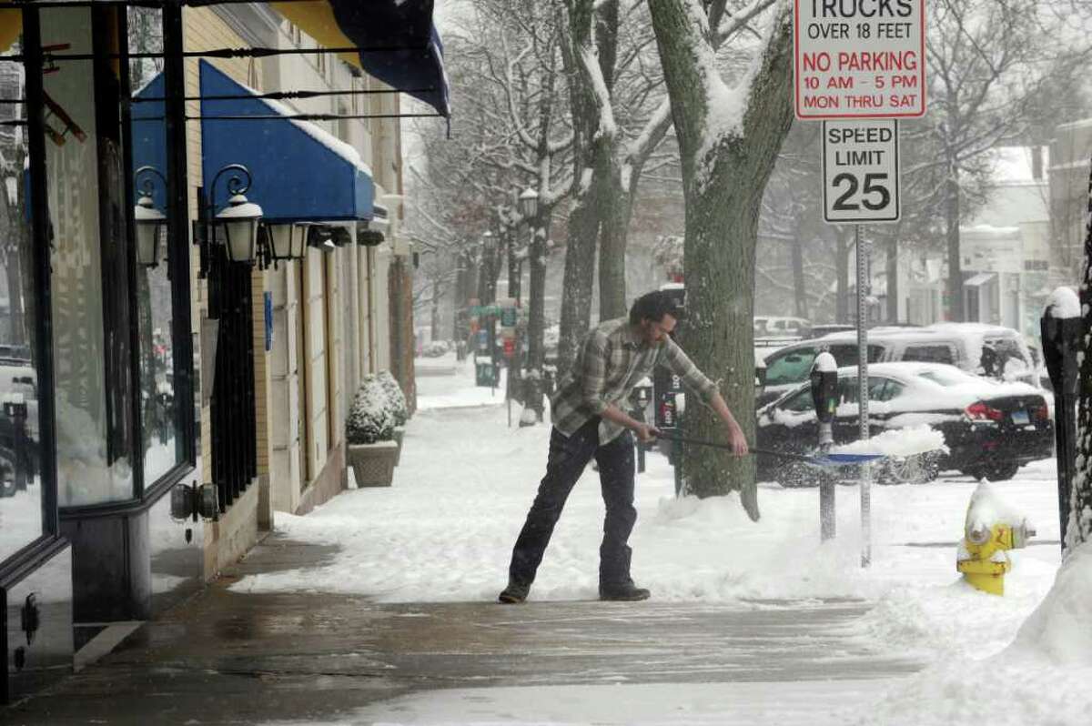 James Burgess, manager of Rugby, shovels snow in front of the store on Greenwich Avenue, in Greenwich, on Wednesday, Jan. 26, 2011.