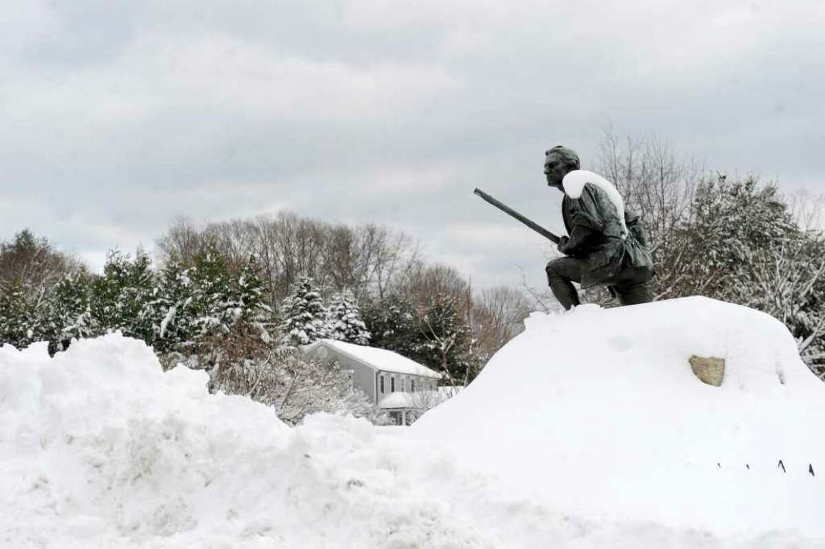 A statue appears to be climbing a mountain of snow at the intersection of Minute Man Hill and Compo Road South in Westport Thursday, January 27, 2011.