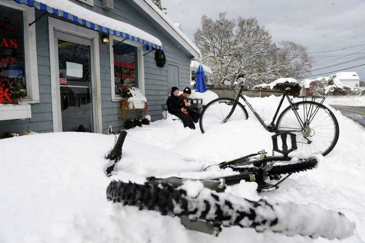 Matteo Bruni, 13, right, and Thomas Rosiello, 12, left, sit outside Elvira's Pizza and Deli after riding their bikes to the shoreline in the snow in Westport Thursday, January 27, 2011.