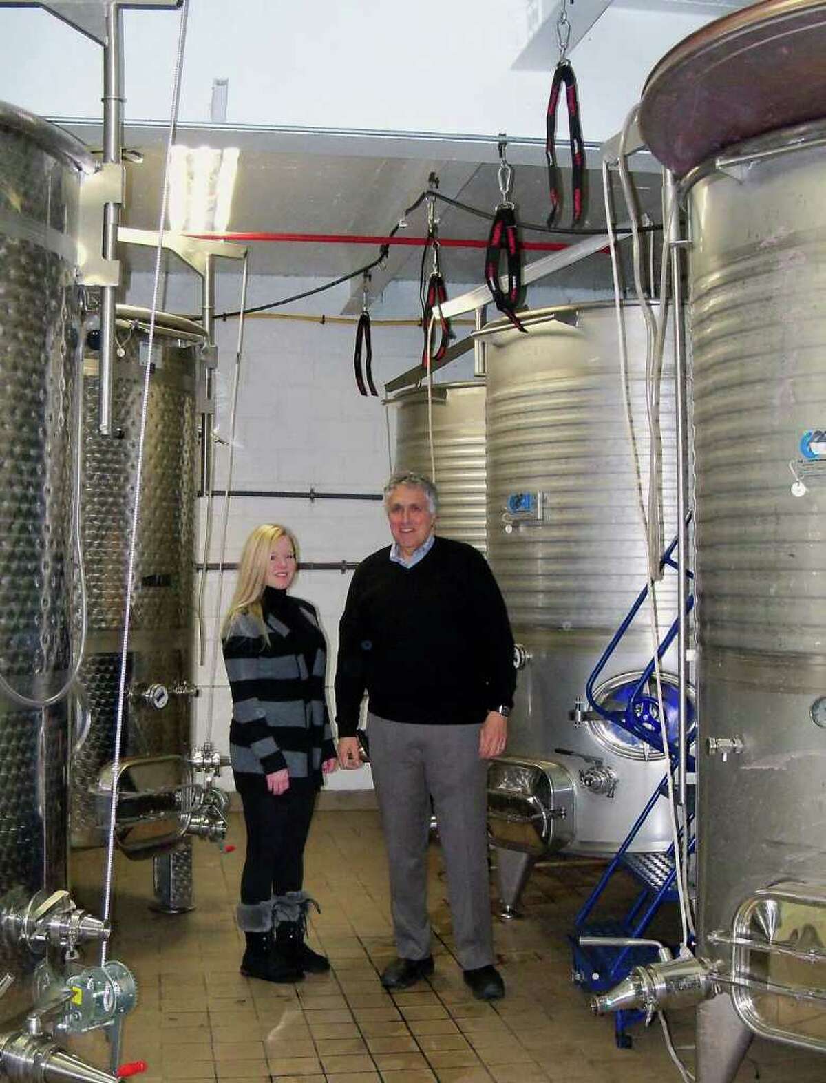Jessica Beale, left, and Tony Izzo stand amid the large vats used to make wine for Black Rock Vintners, a winery in Bridgeport's Black Rock section owned by Izzo, a Fairfield resident.