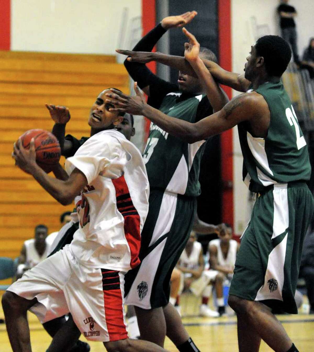 Central's #22 Yaaser Abdulgalil, left, gets pressured by three Bassick players after snatching a Bassick rebound, during boys basketball action in Bridgeport on Friday January 28, 2011.