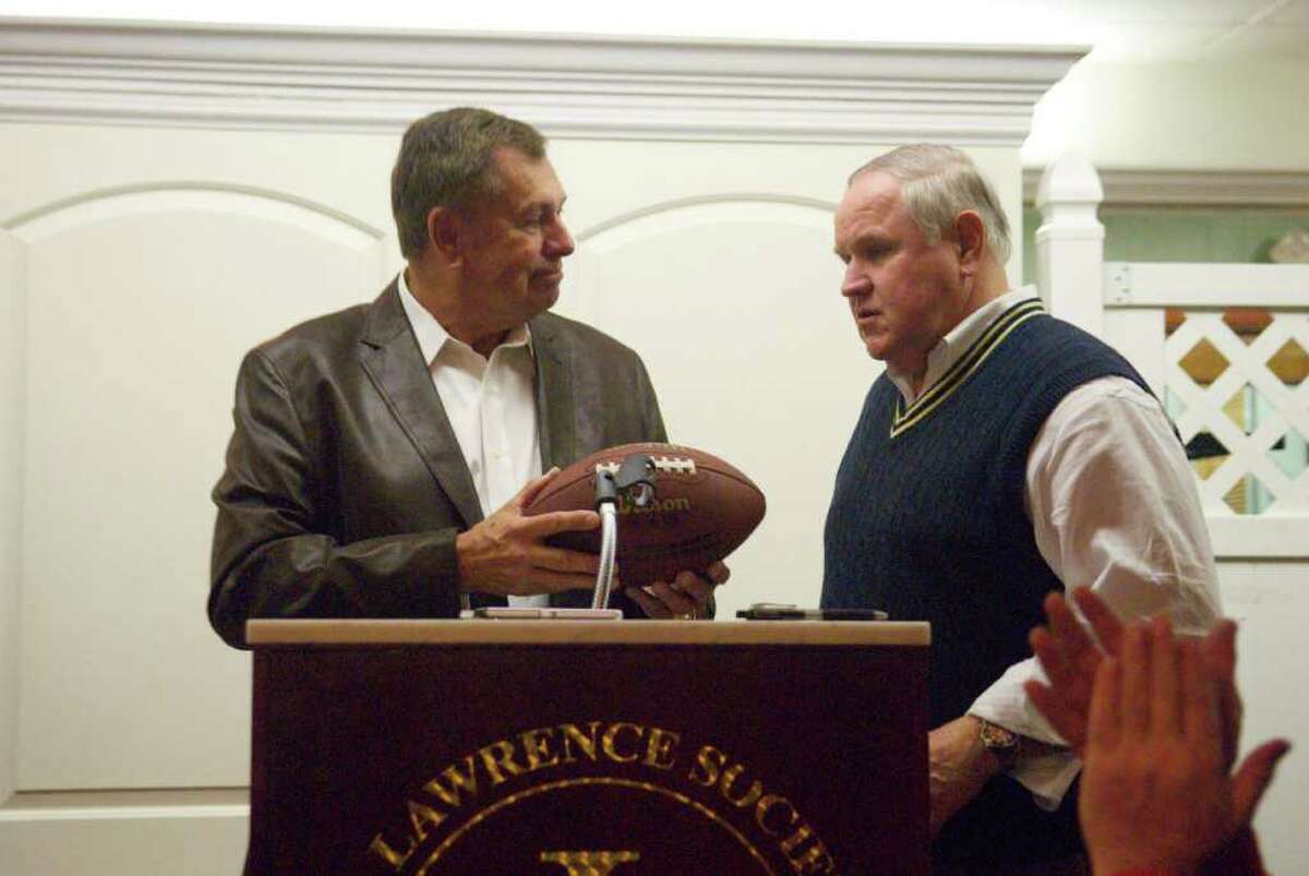 Former Greenwich High School football coach Dave Rice presents a football to Selectman Dave Theis at the dinner at the St. Lawrence Club Friday night. The get-together, organized Theis, honored several former GHS football coaches.