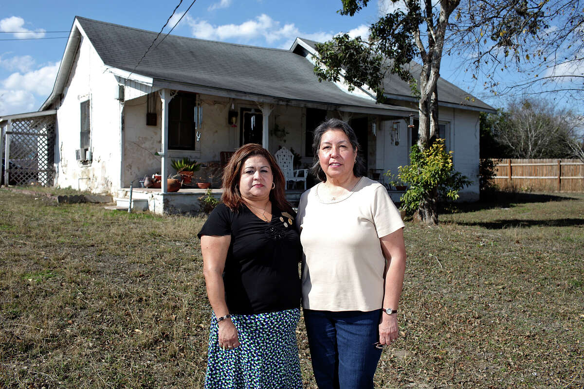 Cousins Teresa Bustillos Abrego (left) and Josephine Rodriguez Mendoza stand outside Mendoza's home. The family now owns just a fraction of the lands granted to it in 1848.