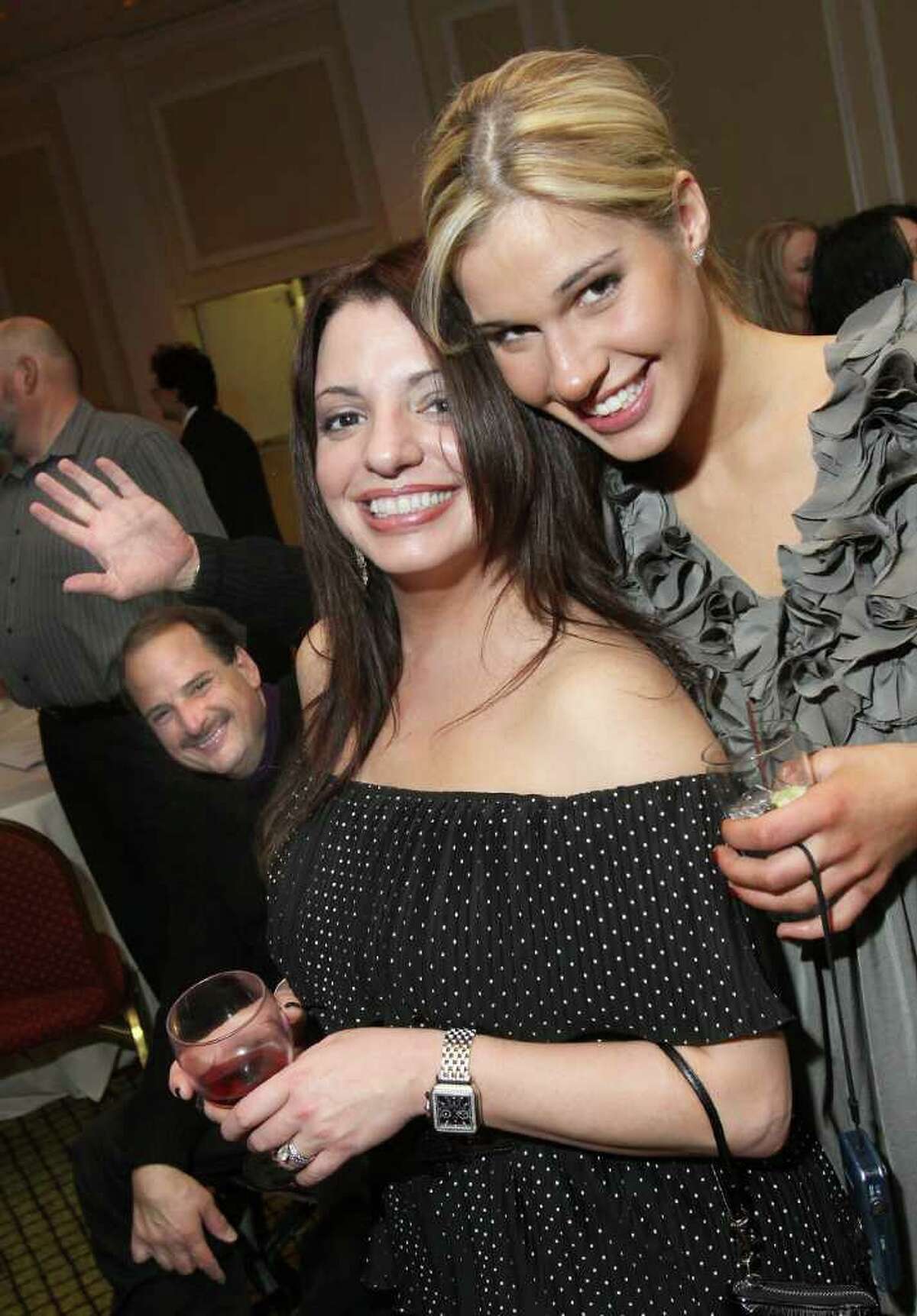 Diana Garcia, center, and Courtney Wojeski pose for a picture while their friend Dan Marko waves in the background, during Taste of Compassion, a Jan. 28, 2011, wine tasting event to benefit the Leukemia & Lymphoma Society Upstate New York/Vermont Chapter. (Joe Putrock / Special to the Times Union)