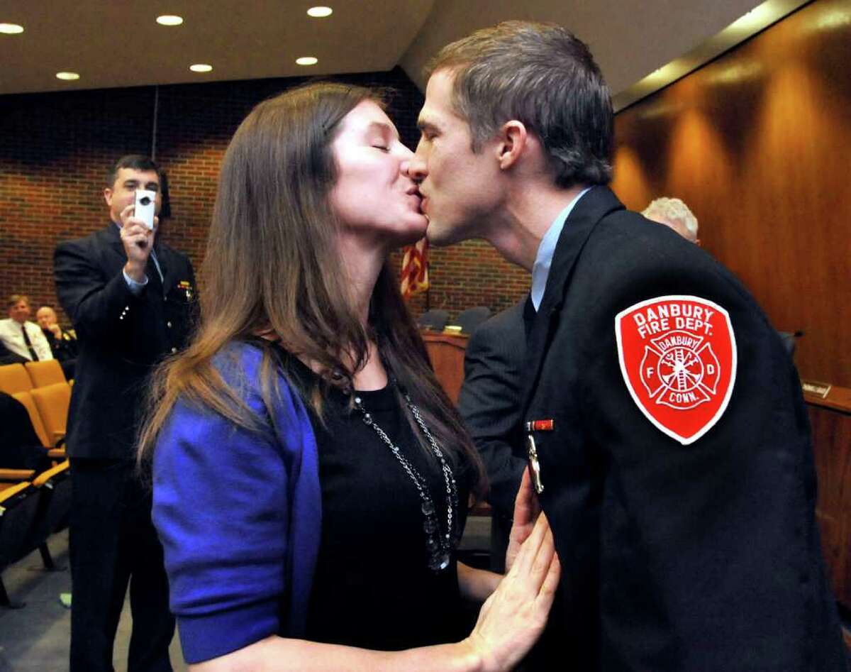 John Halas, of the Danbury Fire Department, gets a congratulatory kiss from his girlfriend, Aly Meeker, after she pinned the badge of lieutenant on him during a ceremony in Danbury's City Hall, Monday, Feb. 7, 2011.
