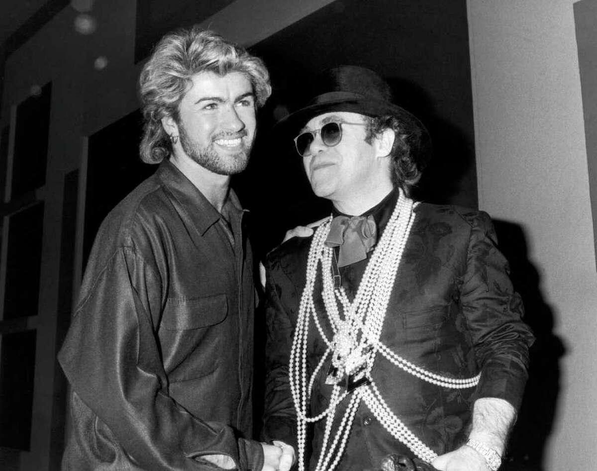 Pop star Elton John (right) congratulates George Michael on winning the Ivor Novello Songwriter of the Year Award at London's Grosvenor House Hotel, 13th March 1985.