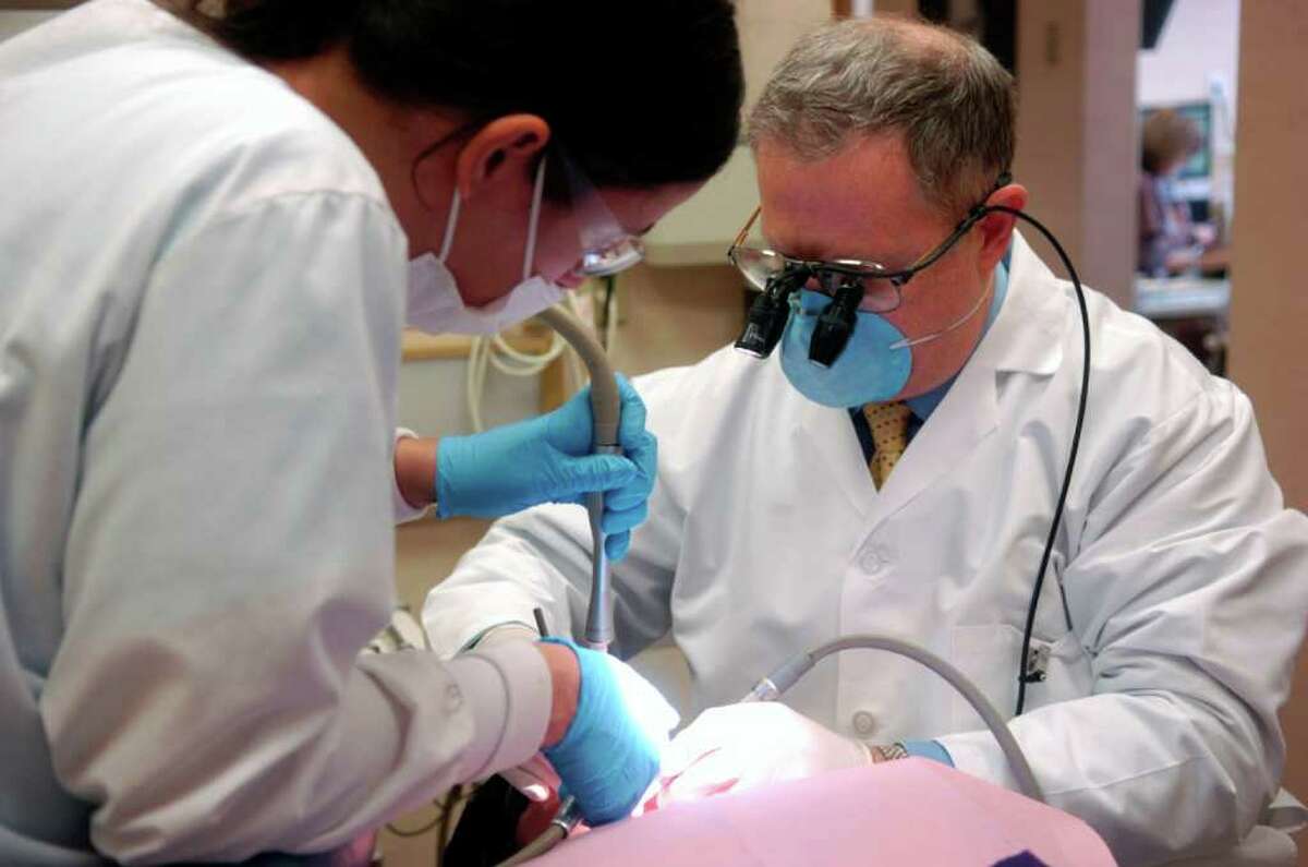 Dr. Mark Samuels is assisted by Myra Febres as they work on patient Nina Delcegno at Lighthouse Dental Care on Thursday, February 10, 2011.