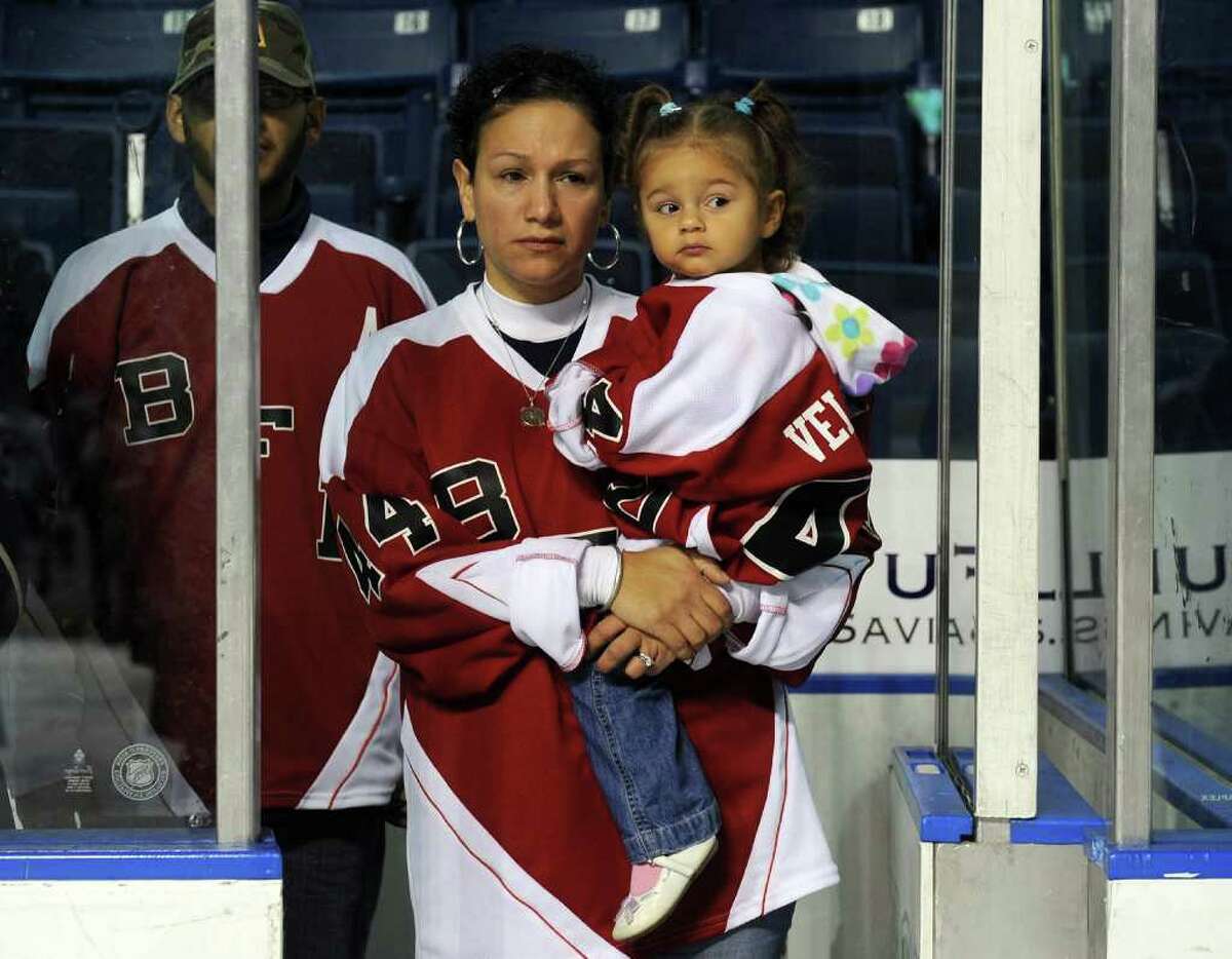 Marianne Velasquez holds her daughter Salina, 2, before a charity hockey game between firefighters from the Bridgeport and Worcester, Mass. fire departments was held at the Arena at Harbor Yard in Bridgeport, Conn. on December 18, 2010. The game was held in honor of two Bridgeport firefighters, Michel Baik and Steven Velasquez, who died fighting a house fire this past July. Velasquez was an active member on the department's hockey team. Proceeds raised from the event go to the Bridgeport Fallen Firefiighters Fund.