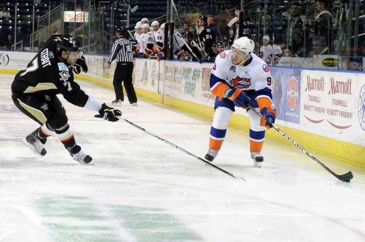 The Sound Tigers' Justin DiBenedetto takes the puck past Wilkes-Barre/Scranton Penguins' Brian Strait during Friday's game at Webster Bank Arena at Harbor Yard on February 11, 2011.