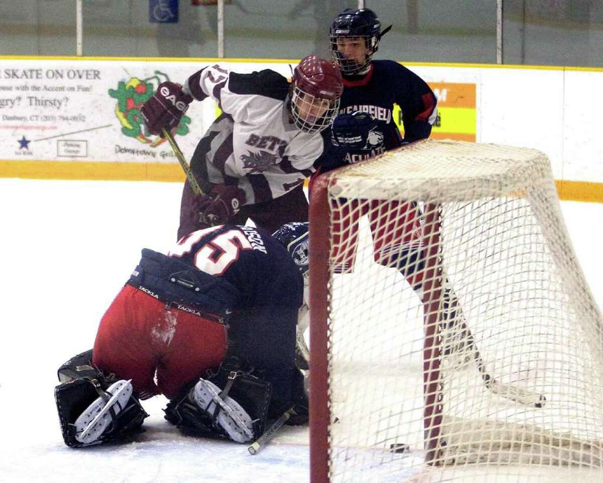 New Fairfield/Immaculate goalie Matt Harrison watches the puck slide wide of the net as Brookfield/Bethel/Danbury's Trevor Kurijaka (17) can't tip it in Monday at the Danbury Arena.