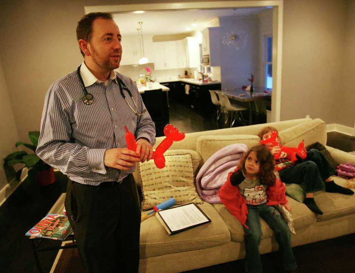 Dr. Edward Kulich of Brooklyn makes balloon animals for patients Genevieve, 5, and Julian Frucht, 7, during a housecall at their Westport home on Sunday, February 13, 2011.