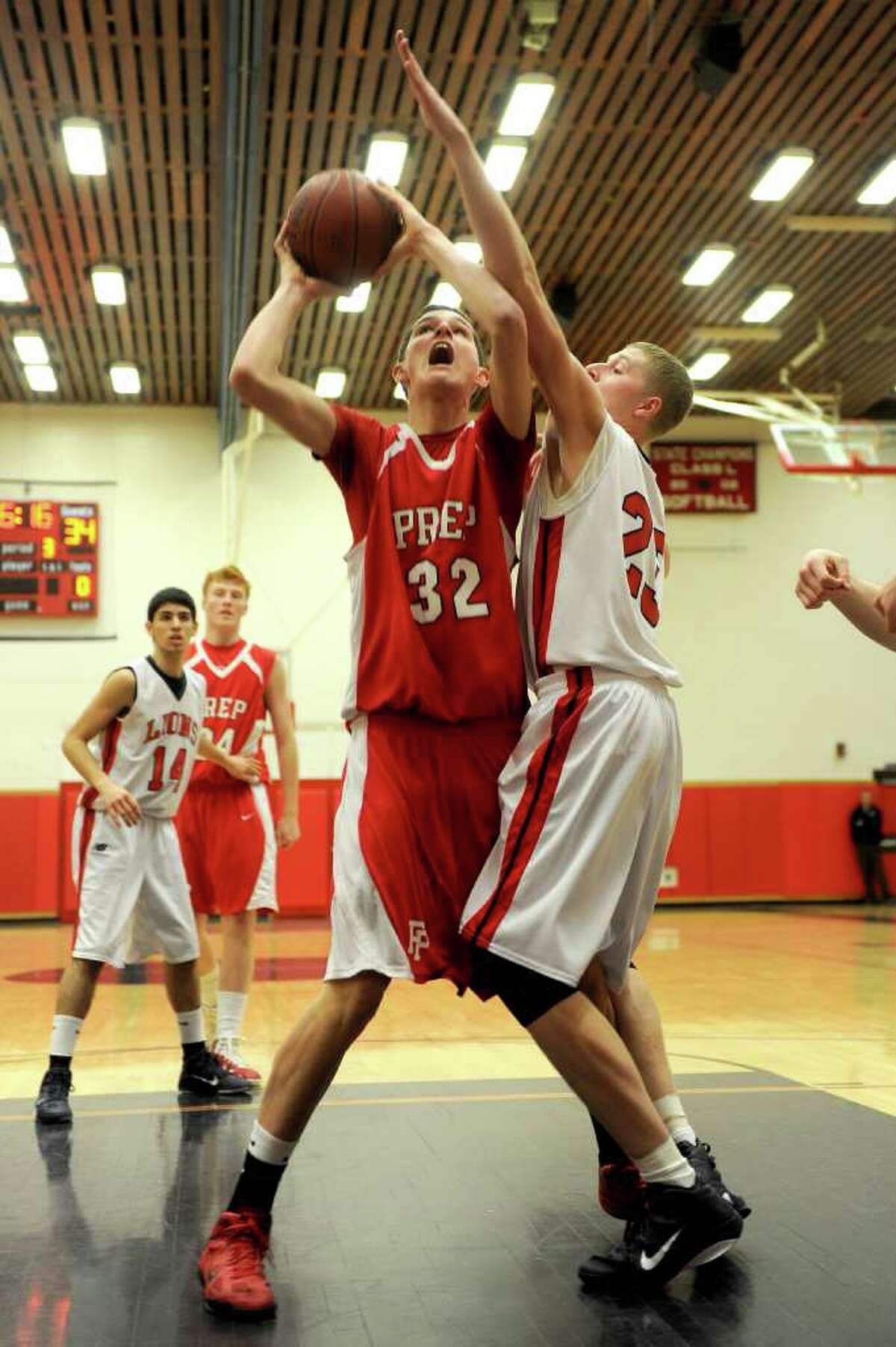 Fairfield Prep's Matt Daley takes a shot as Foran's Austin Woods blocks during Tuesday's game at Foran High School in Milford on February 15, 2011.