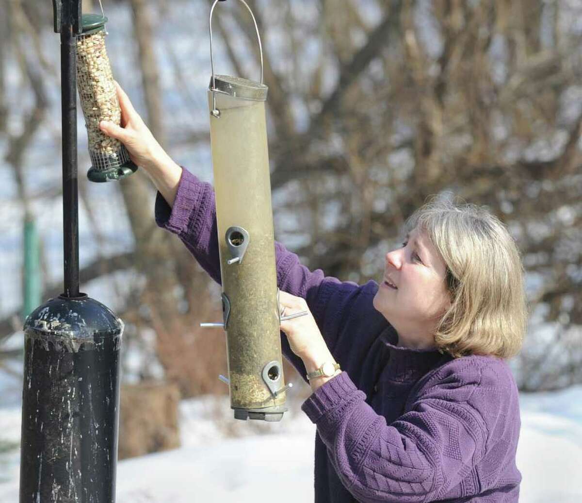 Cynthia Ehlinger of Riverside hangs a bird-feeder after filling it with food, in the backyard of her Riverside home, Thursday afternoon, Feb. 17, 2011. Ehlinger is preparaing for this weekend's Great Backyard Bird Count.
