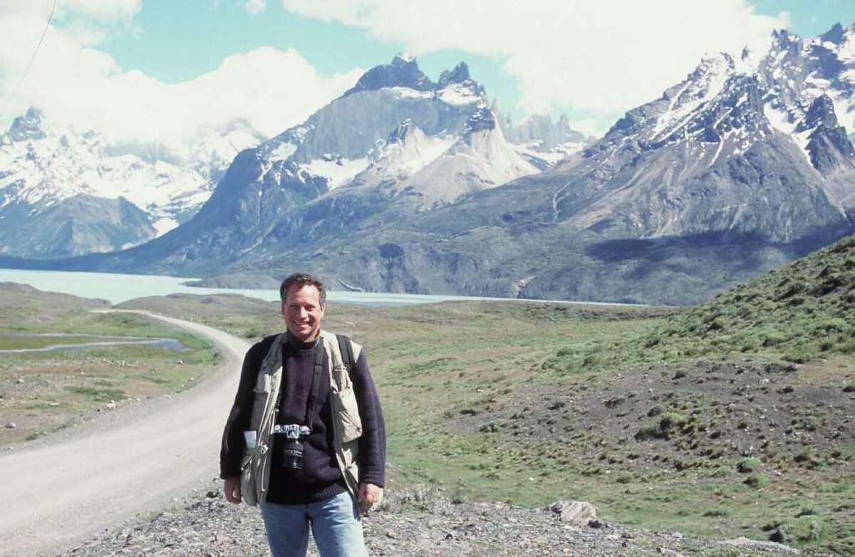 Documentary photographer Daryl Hawk, shown against the backdrop of mountains in the Patagonia region of South America, will give a slide show and lecture on the region in Westport March 9.