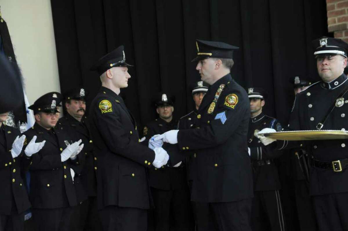 Greenwich Police Officer James Smith receives an award from Sgt. James Bonney at the Silver Shield Association's annual awards ceremony, at the Western Greenwich Civic Center, on Sunday, Feb. 20, 2011.