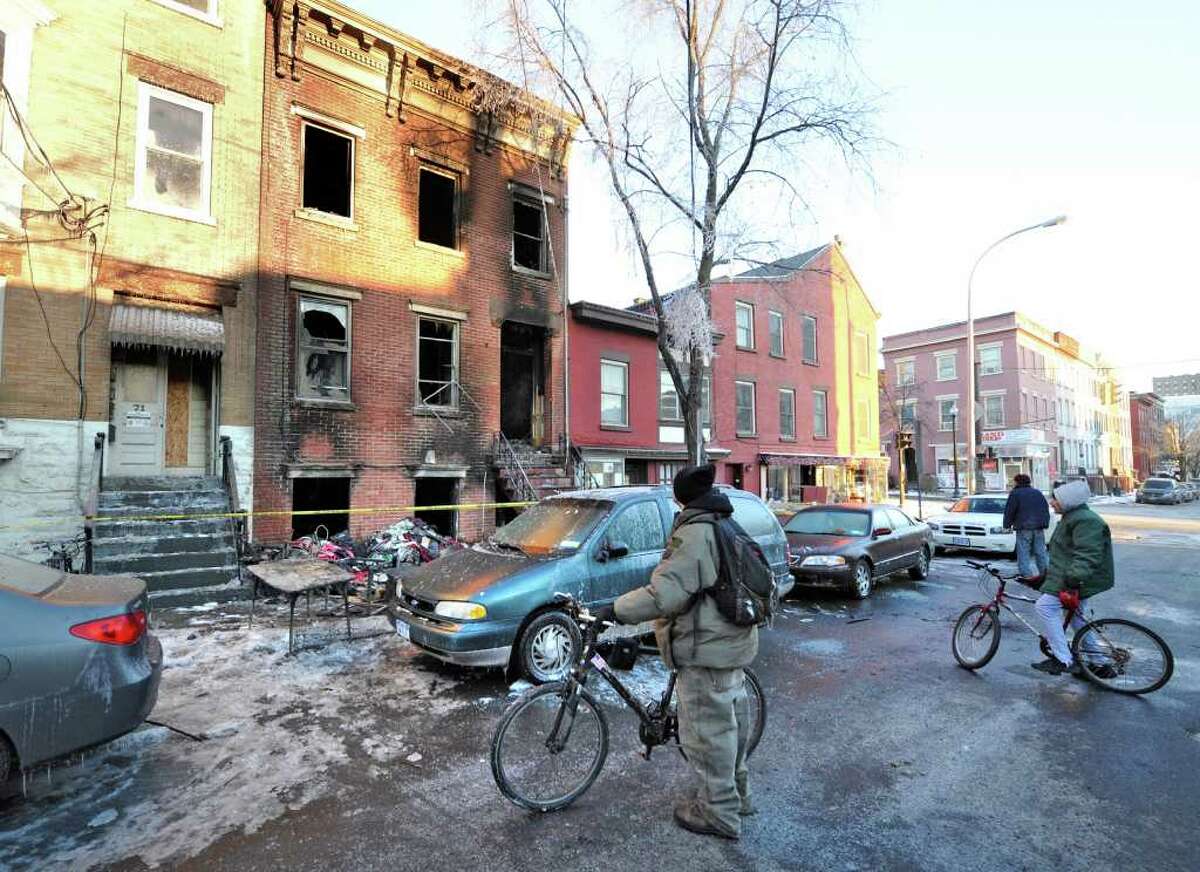 Locals stop by on the way to work to look at the scene of a fatal fire at 69 Grand Street in Albany, New York February 22, 2011. (Skip Dickstein / Times Union)