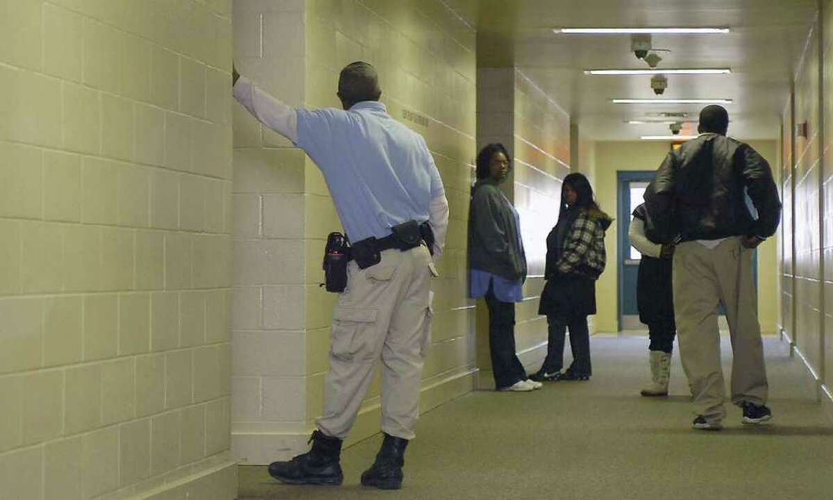 Juvenile Correctional Officers Darris Miller, left, Lois Bias, Eureka Young, and Rhonda Ford, right (partially seen), watch a student (far right) head back to a classroom after getting a drink at the hall water fountain. Miller had just told him to pull up his pants before entering the classroom. Students at the Al Price High School located inside the Al Price Juvenile Correctional Facility, located off Hwy 69/96 in Midcounty, attend classes five days a week just like un-incarcerated kids, to keep up with their peers. The Texas Youth Commission attempts to rehabilitate juvenile offenders as well as educating them while they are incarcerated. Dave Ryan/The Enterprise