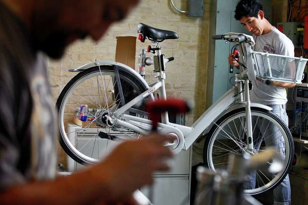 Fernando Guajardo (left), service manager at Bike World on Broadway, and Zack Gonzales, a mechanic at Bike World, work to assemble 140 bikes to be used for San Antonio's new B-cycle bike sharing program at the main office for the program in HemisFair Park on Wednesday, Feb. 23, 2011.