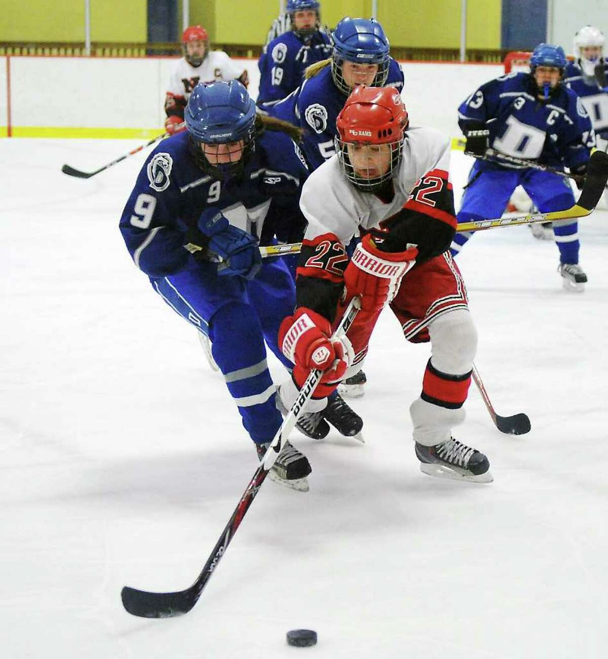 New Canaan High School's Olivia Hompe reaches for the puck with pressure from Darien High School's Sara Shaker in the girls hockey FCIAC championship game at Terry Conners Rink in Stamford, Conn. on Saturday February 26, 2011. New Canaan won 7-1.